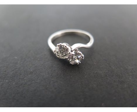 A two stone diamond crossover ring - size L/M - approximately 3.3 grams - each stone approximately 0.46ct - white metal belie