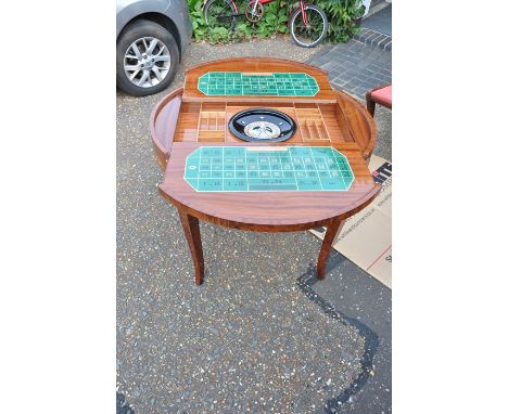 An veneered marquetry games table, the top inlaid with floral foliage lifting away to expose a gaming interior of a felted ca