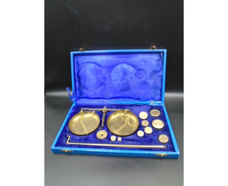 Cased set of brass postal gold weighing scales with weights in purple velvet case