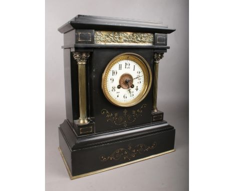 A large black slate mantle clock. Comprising of gilt metal columns and classical decoration. A white enamel dial with Arabic 