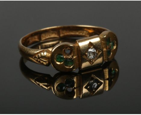 An 18ct gold ring set with a single diamond, flanked by small green coloured stones. Size M. 2.76g.  One green stone missing.