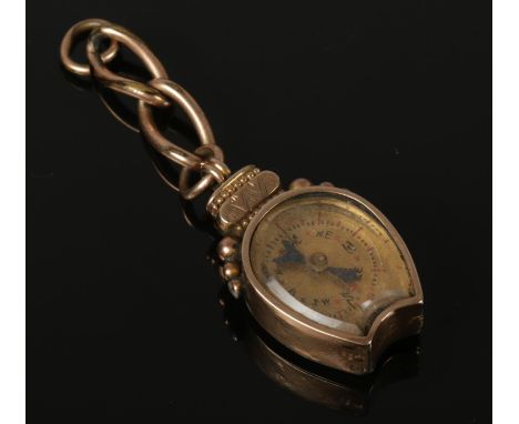 A 9ct gold compass pendant with a hardstone back, carved into a horse's head and shoe on the reverse. Comprises of a bevelled