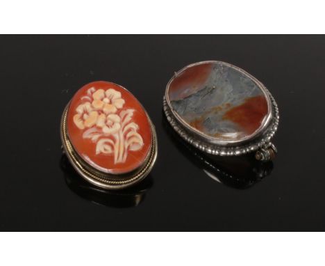 Two brooches. To include a Silver (800) floral cameo brooch and a hardstone brooch with carbon inclusions. Largest K:2.5cm, W