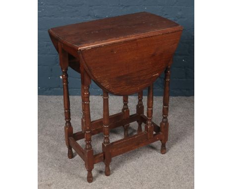 An Oak oval top gate leg table raised on turned supports. H: 76cm, W:60cm, L:90cm fully extended. L:33cm when retracted.  Con