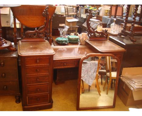 A Victorian mahogany twin pedestal mahogany dressing table, the rectangular swing mirror raised on pierced and carved scroll 