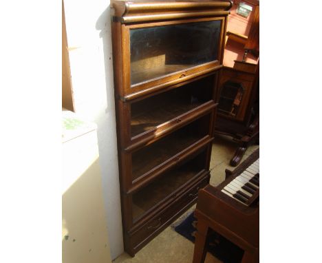 An early 20th Century oak four tier Globe Wernicke sectional glazed bookcase, on plinth base with drawer. 