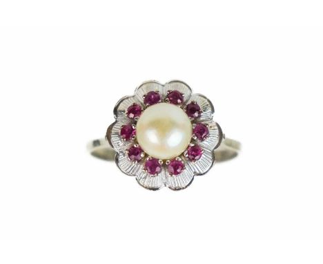 An 18ct white gold cultured pearl and ruby set cluster flower head design ring. The central pearl measuring 7.5mm, surrounded