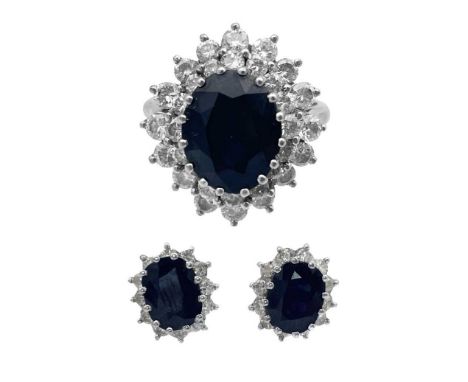 An 18ct white gold diamond and sapphire cluster ring with a pair of matching earrings. The ring set with a deep blue oval cut