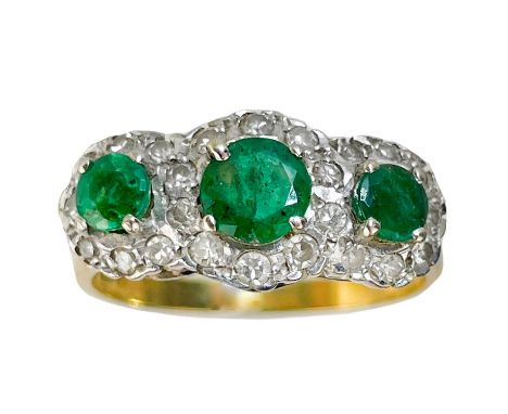 An 18ct gold emerald and diamond triple cluster ring. The principle round cut emerald measuring 5.3 x 3mm, flanked by two sma