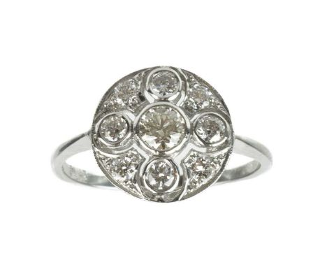 An Art Deco platinum diamond set cluster ring. The circular head pierced and collet set with nine round brilliant cut diamond