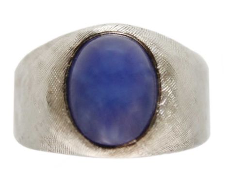 A 14ct white gold synthetic star sapphire set ring. The sapphire measuring 9.7 x 7.8mm, with thick tapering shank with textur