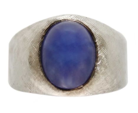 A 14ct white gold synthetic star sapphire set ring. The sapphire measuring 9.7 x 7.8mm, with thick tapering shank with textur