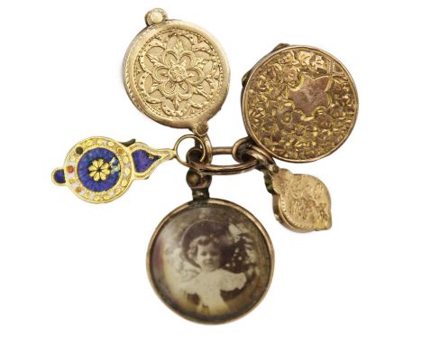 A selection of four gold charms and a rolled gold frame glazed panel locket. To include a circular pierced gold charm contain