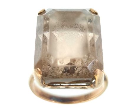 A 9ct smoky quartz set cocktail ring. The rectangular step cut stone measuring 20 x 15mm, size P, 10g.The stone is scratched.