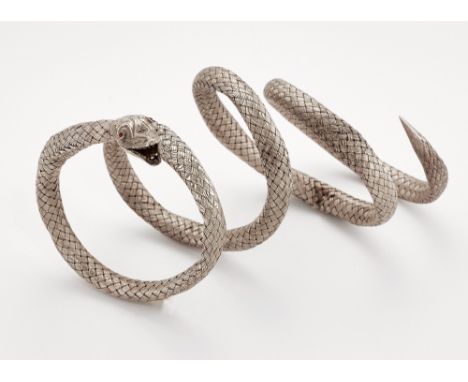 A SERPENT BANGLE, the coiled body formed of woven white metal, to a foliate engraved head, modelled with an open mouth and re