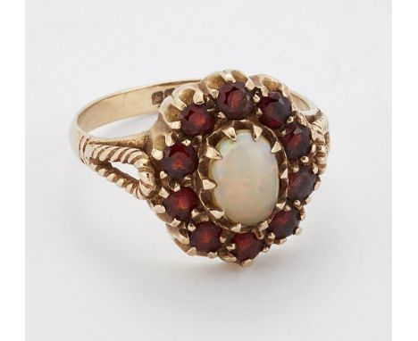 A 9 CARAT GOLD OPAL AND GARNET CLUSTER RING, an oval opal within a border of round-cut garnets, to forked rope shoulders, hal