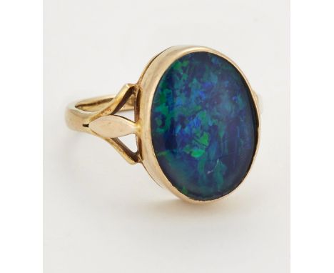 A 9 CARAT GOLD COMPOSITE BLACK OPAL RING, an oval composite black opal in a bezel setting to forked shoulders, hallmarked Lon