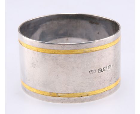 AN ART DECO SILVER AND ENAMEL NAPKIN RING, probably by Adolph Scott, Birmingham 1930, circular with twin bands of yellow enam