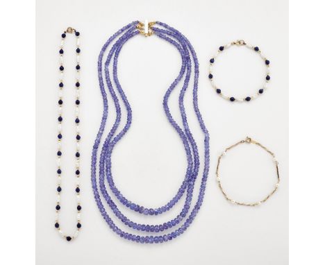 A TANZANITE BEAD NECKLACE, three strands of graduated faceted tanzanite beads to a rectangular clasp, marked '14K', length 43