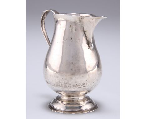 A GEORGE II SILVER CREAM JUG,&nbsp;by Thomas Rush, London 1733, of pitcher form, raised on a domed and reeded moulded foot. 8