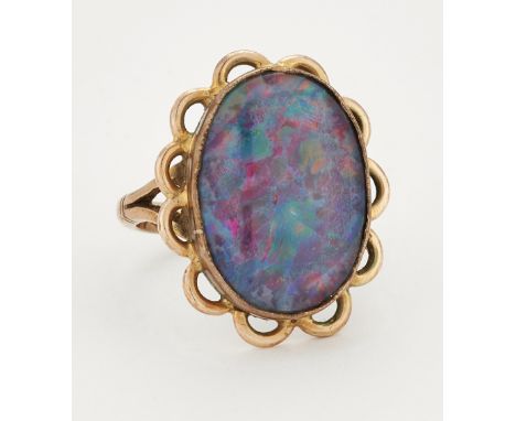 A COMPOSITE OPAL RING, an oval composite opal in a bezel setting within a pierced frame, marked '9CT', ring size J1/2. 5.2 gr