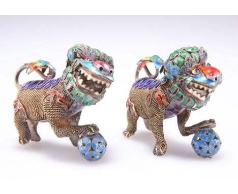 A PAIR OF CHINESE SILVER AND ENAMEL MODELS OF BUDDHIST LIONS, early 20th Century, each with rotating head. (2) 7cm longCONDIT