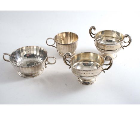 A MIXED LOT:- Two small trophy cups with upswept, harp-shaped handles, both inscribed, and a small mug & matching sugar bowl 