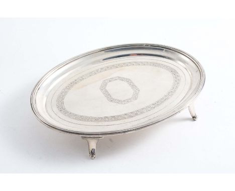 A GEORGE III ENGRAVED OVAL TEAPOT STAND with a reeded border and elongated bracket feet, by William Bennett, London 1805;  6.