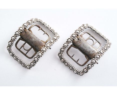 A PAIR OF GEORGE III SMALL MOUNTED STEEL SHOE BUCKLES with borders of repeating faceted florets and a button operated, quick 