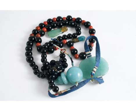 A STRING OF CHINESE MANDARIN BEADS of black glass with red pottery spacers, jade flat plaque and pendants (incomplete); appro