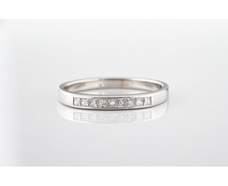 An 18ct white gold princess cut diamond half eternity ring, channel set with nine diamonds, total 0.25ct, ring size N.