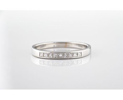 An 18ct white gold princess cut diamond half eternity ring, channel set with nine diamonds, total 0.25ct, ring size N.