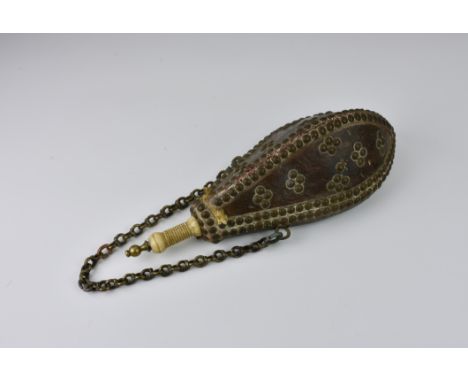 A Moroccan wooden powder flask, covered with leather and brass stud pattern, camel bone stopper.