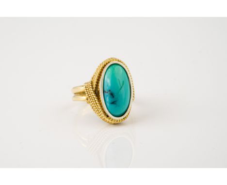 An 18ct gold and turquoise neo-classical style ring, the oval cabochon turquoise in a polished setting with crossover braided