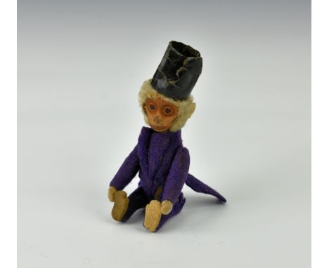 A rare novelty Schuco perfume monkey, circa 1930, dressed in purple felt with top hat, bottle/flask hidden inside the body, 4