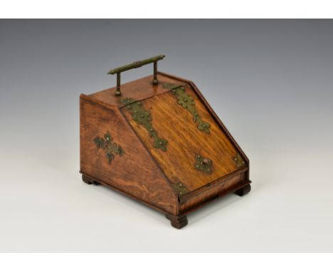 A novelty Victorian oak tea caddy, fashioned as a coal scuttle, embellished with ornate brass work, the front door opening to