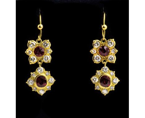 A pair of 18ct yellow gold, ruby and diamond drop earrings, the upper floral clusters with a central round cut ruby, the lowe