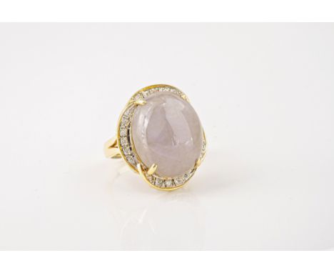 An 18ct gold, grey jade and diamond cluster ring, the large oval cabochon jade in mottled grey, within a four lobed border se