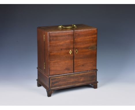 A 19th century mahogany travelling medicine chest or apothecary cabinet, with brass top carrying handle above two hinged door