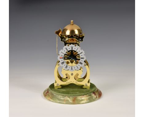 A small brass skeleton clock by Thwaites & Reed, late 20th century, with heart shaped scroll frame, the silvered Roman chapte