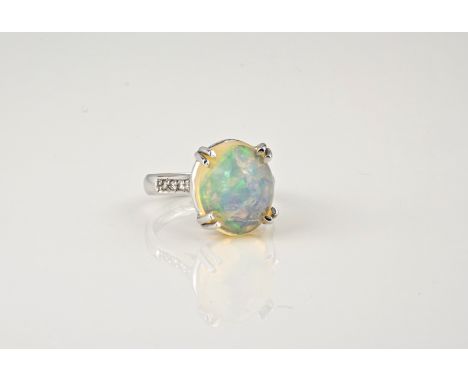 An 18ct white gold, opal and diamond ring, the oval 6.66ct, high domed jelly opal in a four claw setting over diamond set sho