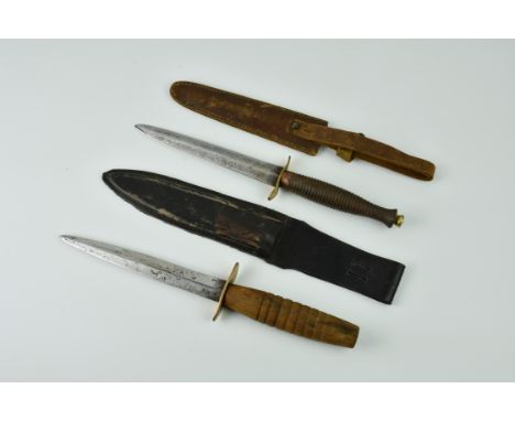 Two Fairbairn-Sykes style fighting knives, with scabbards., the first with metal turned handle and brass fittings, blade, 6in