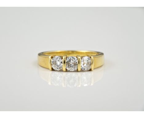 An 18ct gold three stone diamond ring, hallmarked London 1989, bar set with three brilliant cut diamonds, total weight approx