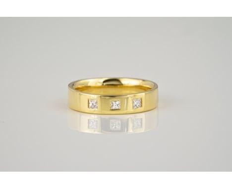 An 18ct yellow gold and princess cut diamond three stone ring, the polished band with three inset diamonds, total 0.21ct, rin