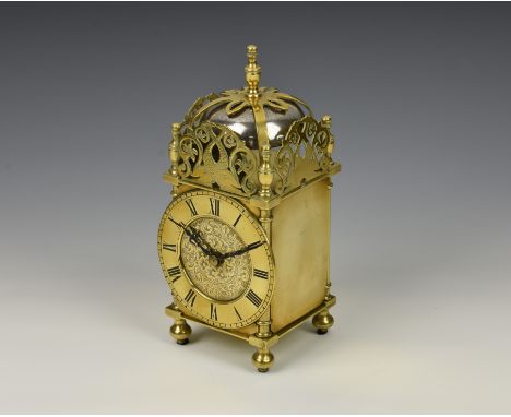 An early 20th century mantel clock in the form of a lantern clock, with brass 10.4cm. Roman dial, the case with twin dolphin 