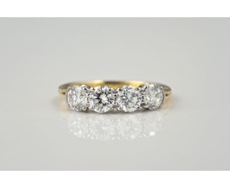 An 18ct yellow gold and diamond four stone ring, made by N. St. J. Paint &amp; Son, Guernsey, the four brilliant cut diamonds