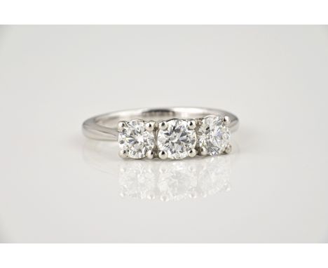 A platinum and diamond three stone ring, the three brilliant cut diamonds totalling 1.50ct, over tapered shoulders, ring size