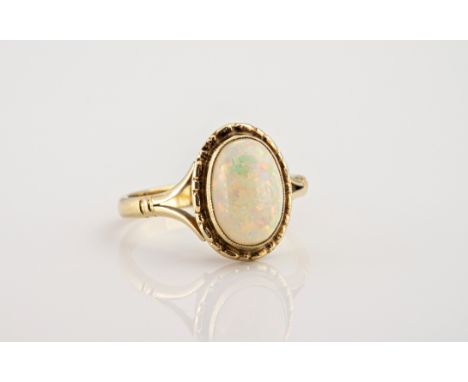 A 9ct gold and opal ring, the oval harlequin opal over bifurcated shoulders, ring size M.