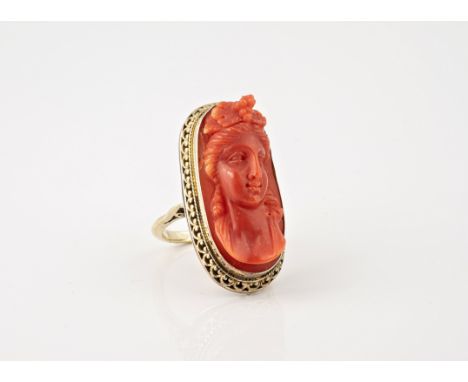 A vintage 9ct yellow gold and red coral cameo ring, the carved coral cameo depicting a classical beauty, in a pierced Victori