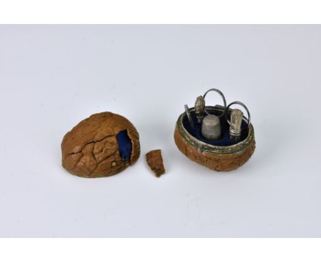An antique natural walnut sewing etui, probably French, 19th century, the walnut enclosing miniature steel sewing implements,